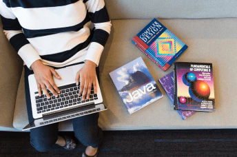 Person training on her laptop surrounded by different technical books